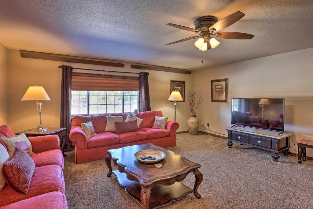 a living room with red furniture and a flat screen tv at Centrally-Located Deadwood Apt with Mountain Views! in Deadwood