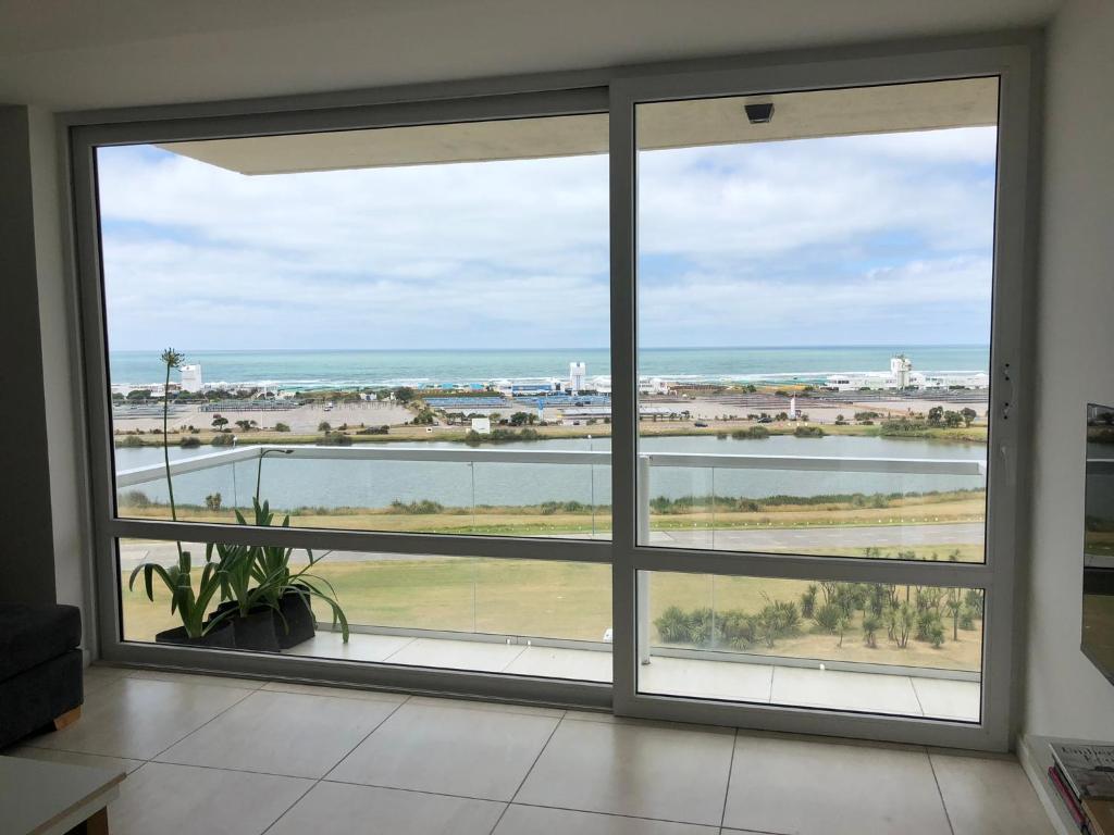 マル・デル・プラタにあるSusurros del Mar, Amplio semi-piso frente al marの海の景色を望む客室内の大きな窓