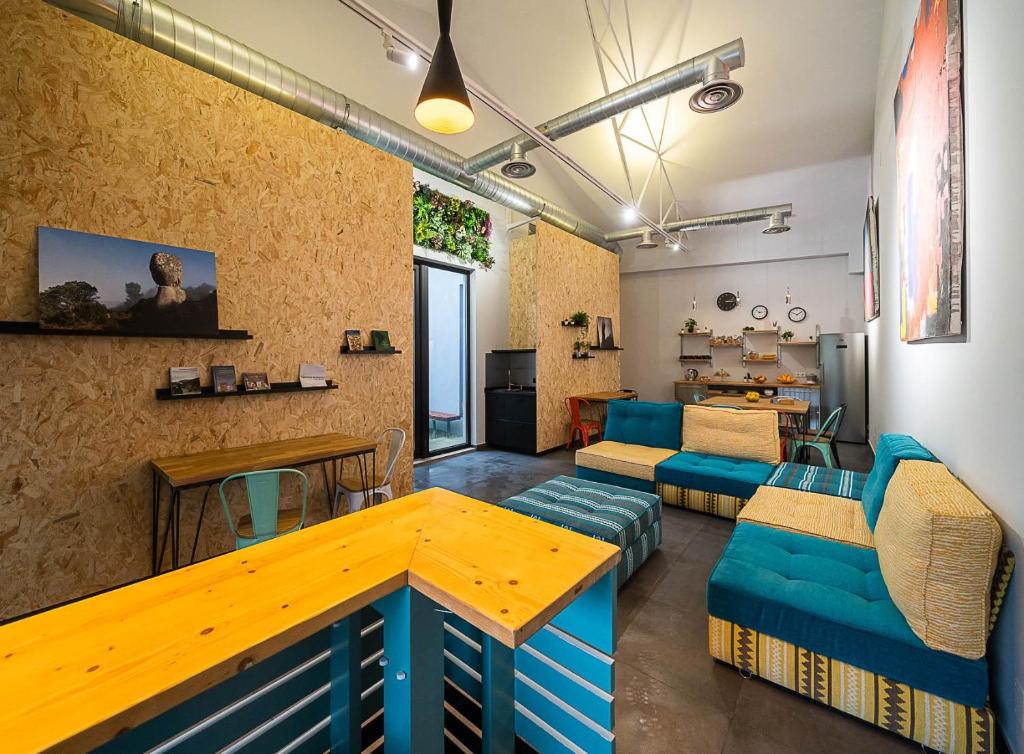 a living room with a table and blue couches at Dpaso hostel in Chantada