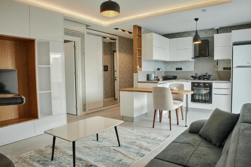 een woonkamer en een keuken met een bank en een tafel bij Sky Garden Suites in Adana