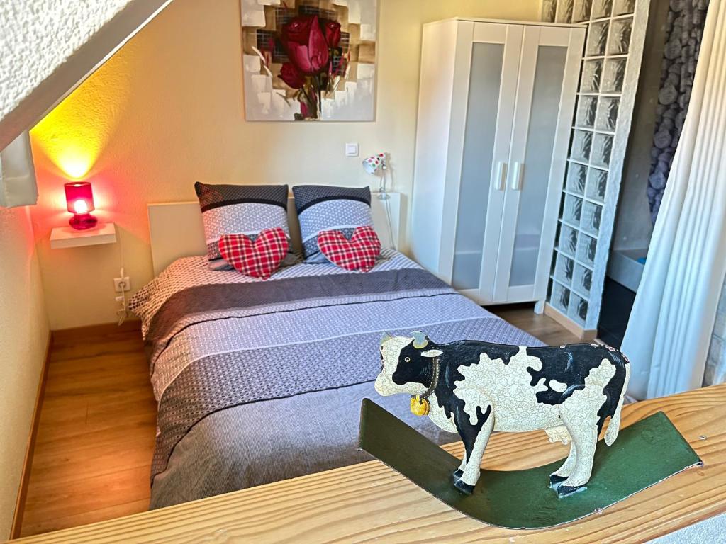 - une chambre avec un lit avec une vache dans l'établissement Gite St Léon à Eguisheim, à Eguisheim