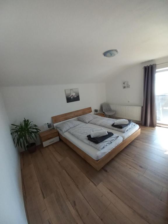 sypialnia z dużym łóżkiem i drewnianą podłogą w obiekcie Appartement Müllner w mieście Kirchdorf in Tirol