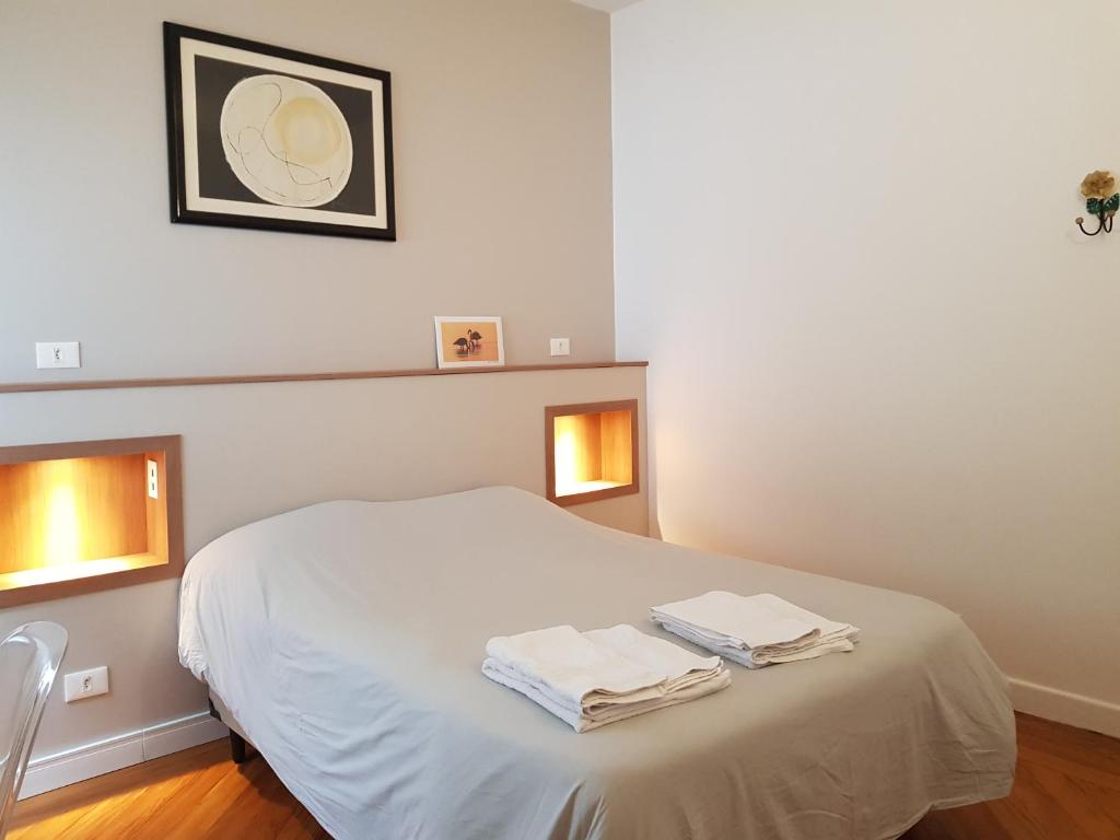 a bedroom with a white bed with two towels on it at Casa Saint Hilaire in São Paulo