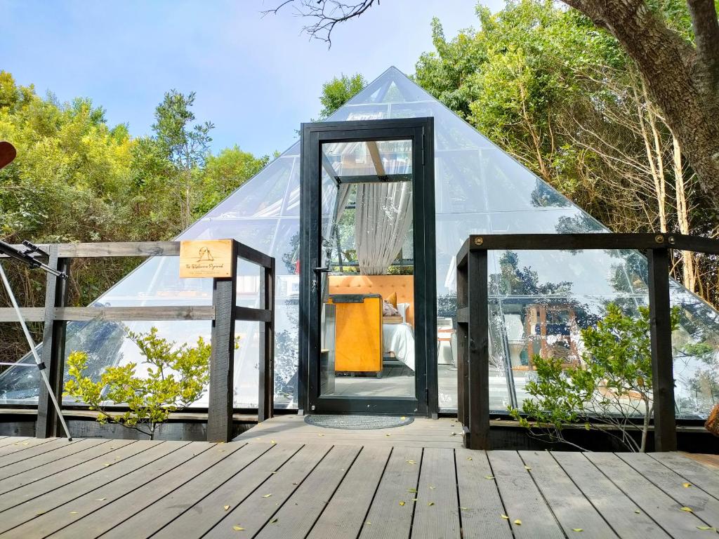 una casa de cristal con una puerta en una cubierta en The Tsitsikamma Pyramid, en Stormsrivier