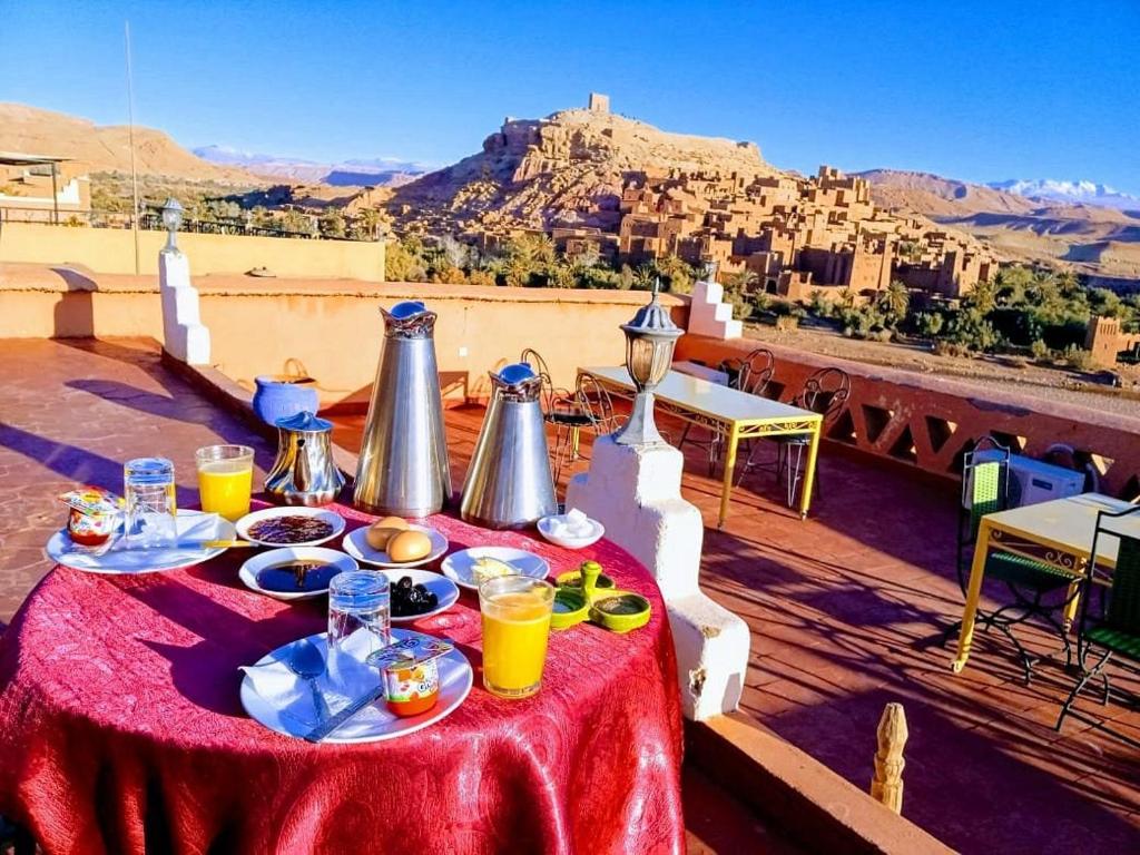 uma mesa com comida e bebidas em cima de um telhado em La Fibule D'or em Aït-Ben-Haddou