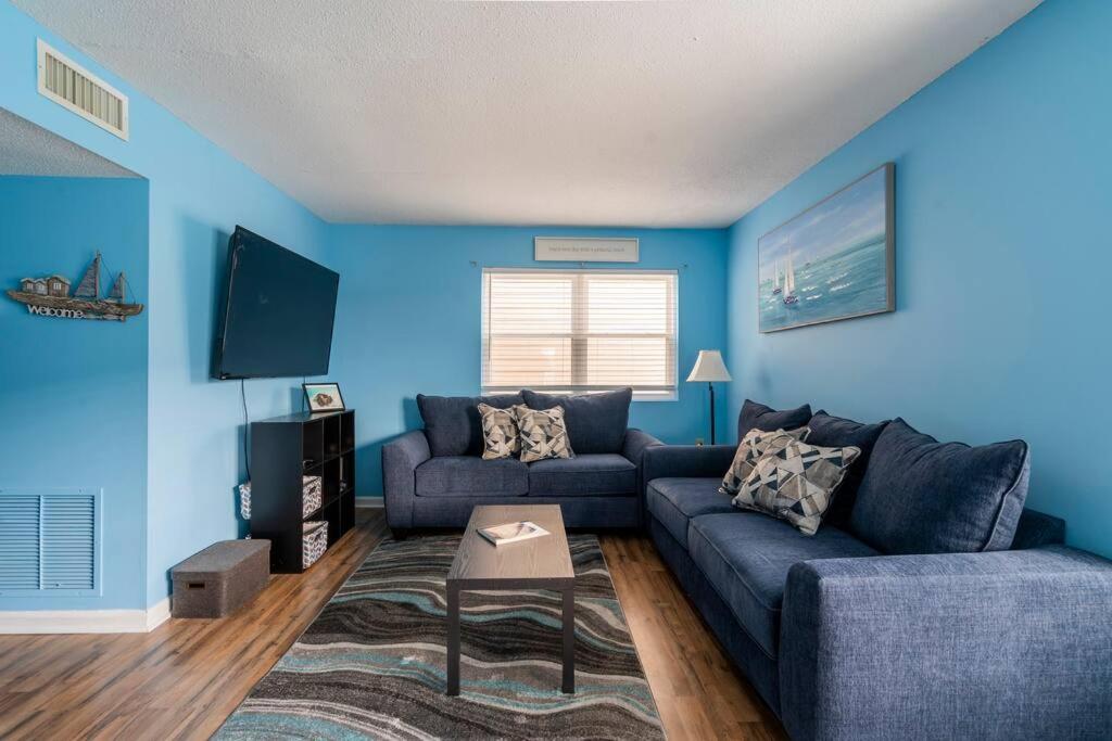 uma sala de estar com paredes azuis e um sofá azul em Beautiful Blue Ocean Condo em Myrtle Beach