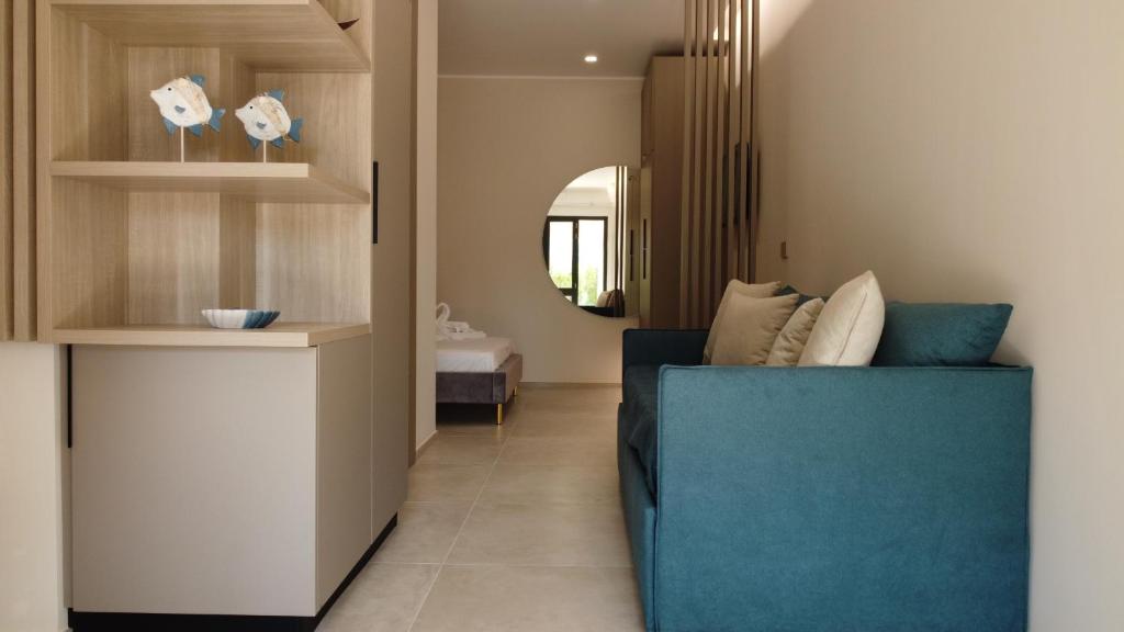 sala de estar con sofá azul y espejo en Perla dello Ionio luxury apartments, en Torre Lapillo