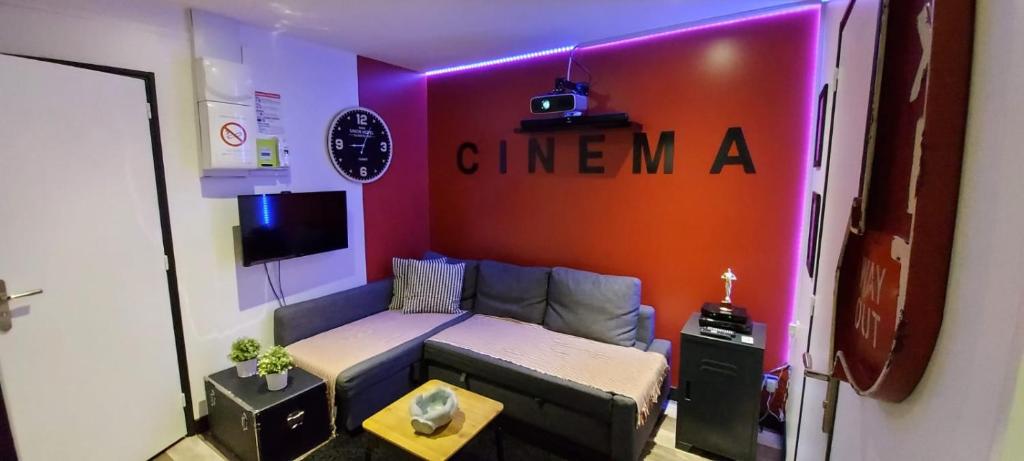- un salon avec un canapé et un panneau mural dans l'établissement Appartement Cinéma vidéo-projecteur et garage, à Honfleur