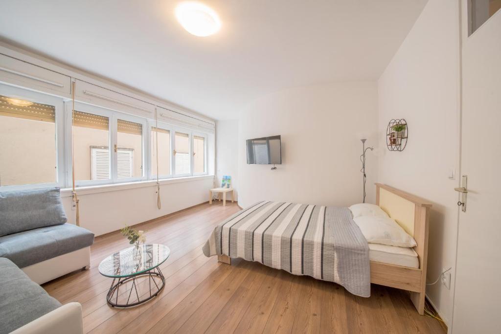 sypialnia z łóżkiem, kanapą i stołem w obiekcie Aurora Apartment Zadar w mieście Zadar
