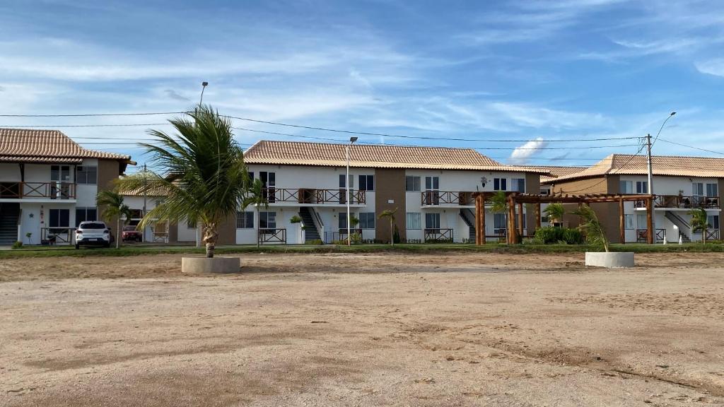 a row of houses with a palm tree in front of them at Brisas do Lago in Paulo Afonso