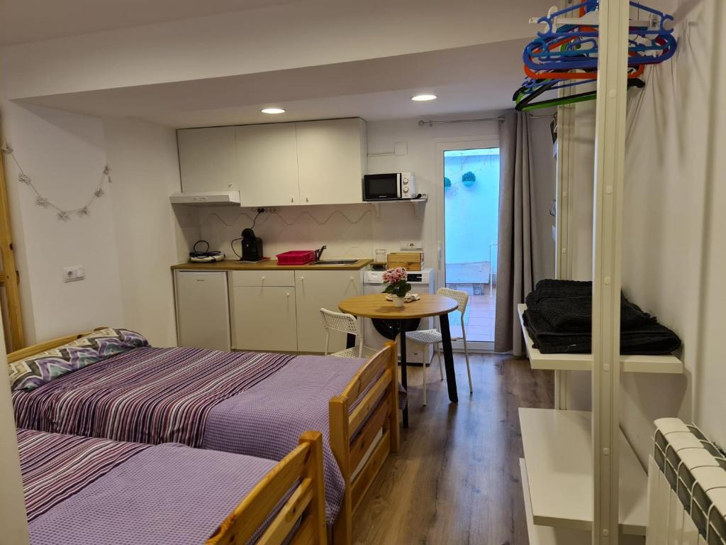 Cet appartement comprend une chambre avec deux lits et une cuisine avec une table. dans l'établissement Casa de Mares y sueños, à Rincón de Soto
