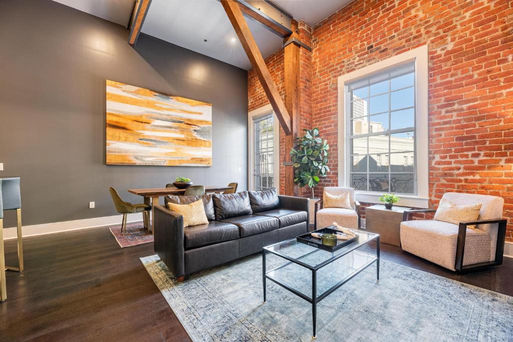 a living room with a couch and a brick wall at The Iris in New Orleans