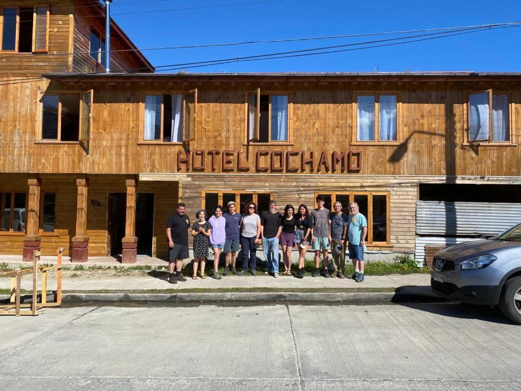 un grupo de personas de pie en frente de un edificio en Hotel Cochamó en Cochamó