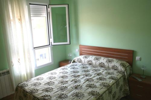 1 dormitorio con cama y ventana en CASA RURAL HOCES DEL MESA, en Jaraba