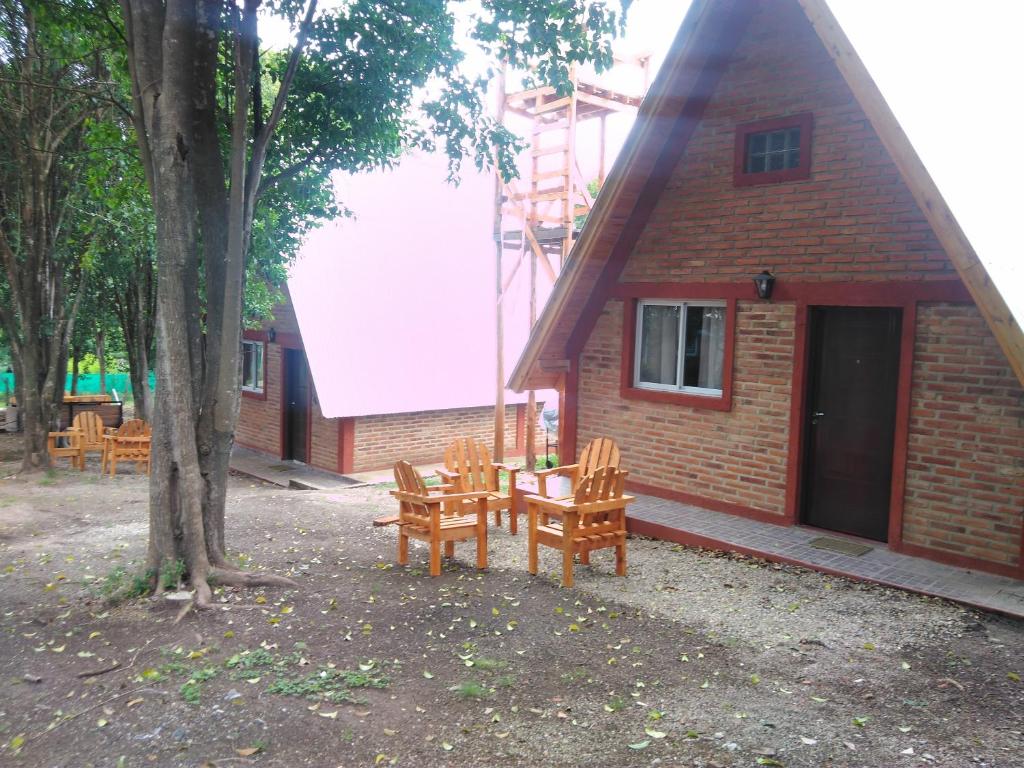 a group of chairs and a table in front of a building at Alpinas Sol y Luna VGB in Villa General Belgrano