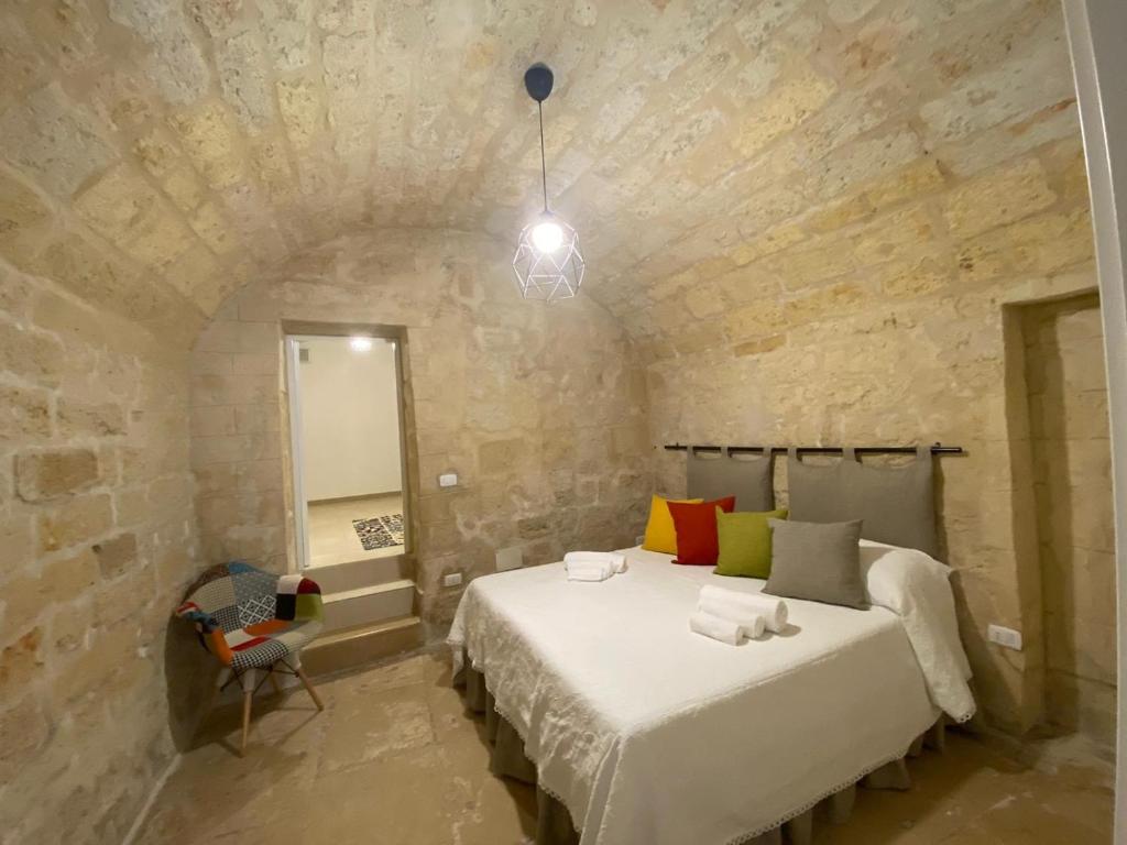 a bedroom with a bed in a stone wall at L’INFANZIA HOLIDAY HOME in Bari