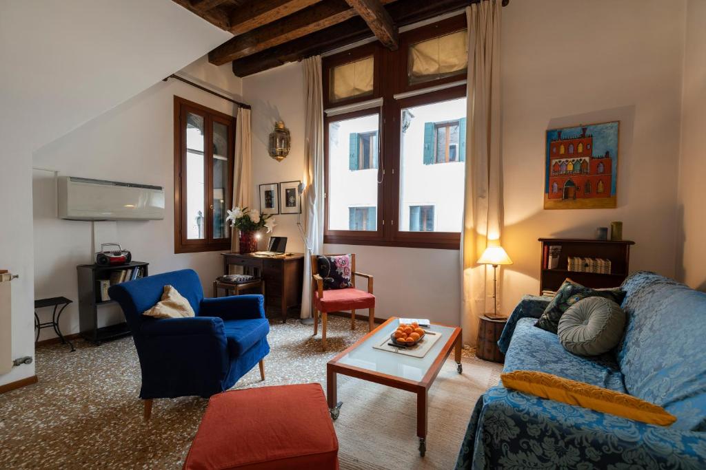 a living room with a blue couch and a table at Cà Paola Cozy Venice Apartment in Venice