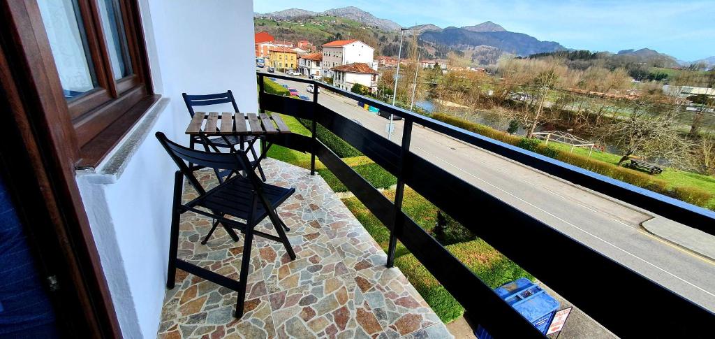 a balcony with a table and a bench on a balcony at Piso El PUNTUAL de arriondas in Arriondas