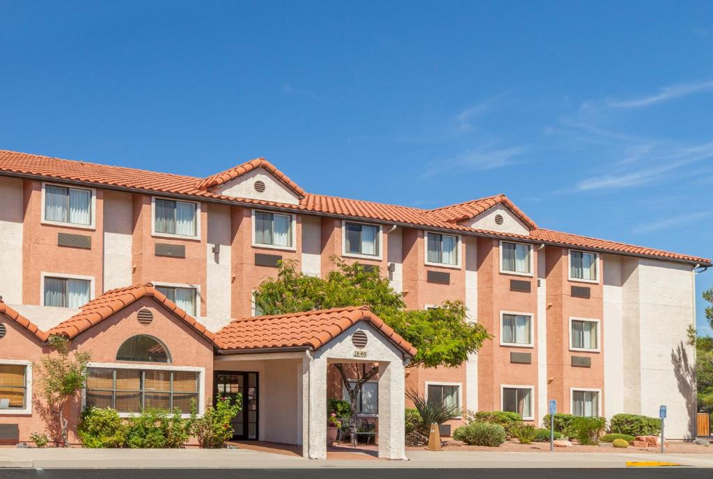 a large brick building with red roof at Days Inn by Wyndham Camp Verde Arizona in Camp Verde