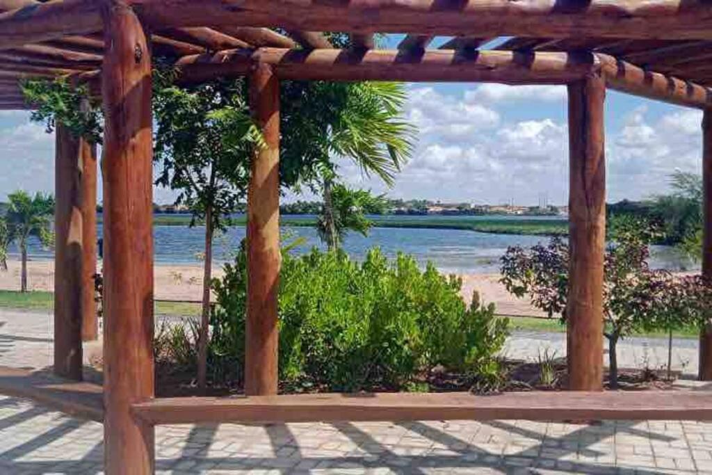 a wooden pergola with a view of a beach at Brisas do Lago I in Paulo Afonso
