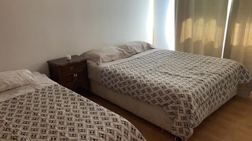 um quarto com duas camas e uma mesa de cabeceira em Bienvenido a Campo Alerce em Teno
