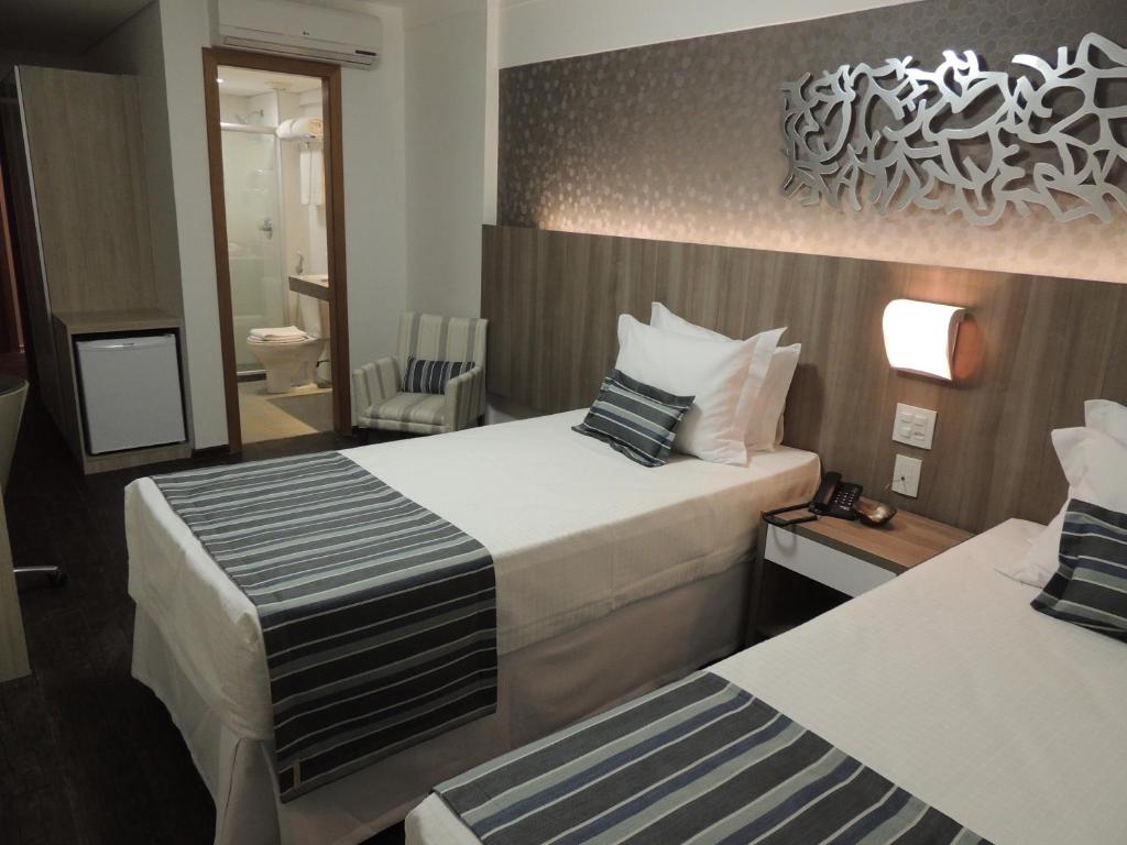 Cama ou camas em um quarto em Allia Gran Pampulha Suites