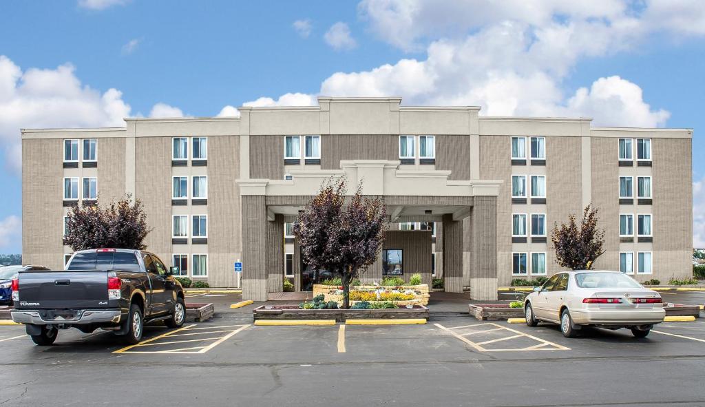 un grand bâtiment avec des voitures garées dans un parking dans l'établissement Baymont by Wyndham Dunmore, à Dunmore