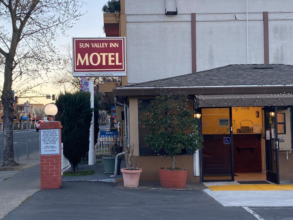 una señal para un motel frente a un edificio en Sun Valley Inn, en Pleasant Hill