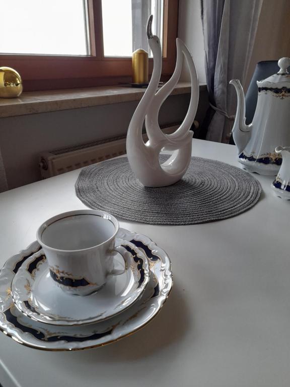 a cup and a plate and a vase on a table at Ferienwohnung Lucky Luggi in Bad Griesbach in Bad Griesbach