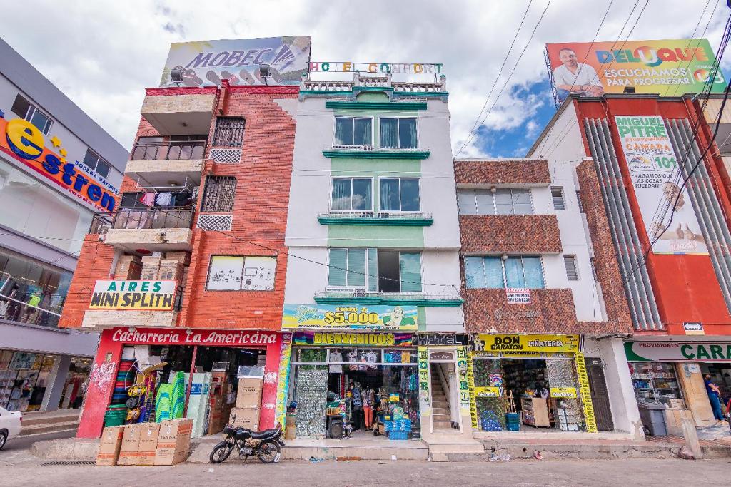 a tall building with shops on a city street at Ayenda Confort De La Guajira in Ríohacha