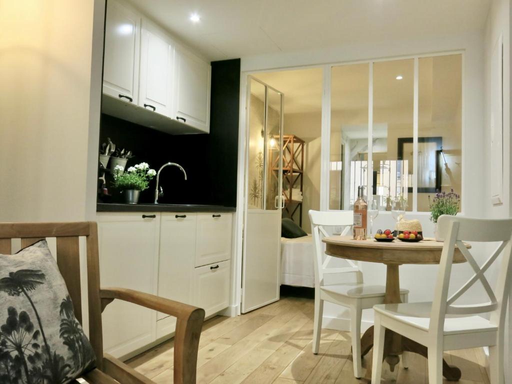 a kitchen and dining room with a table and chairs at Les Petits Volets 3 appartements au choix in Antibes