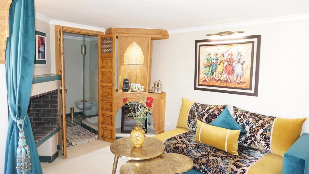 uma sala de estar com um sofá e uma lareira em Riad Samsli em Marrakech