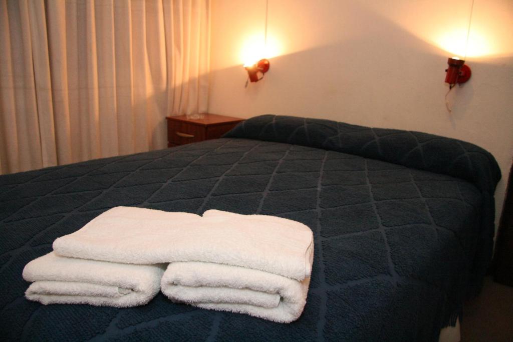 a bed with two white towels on top of it at Hotel Yaro in Gualeguaychú