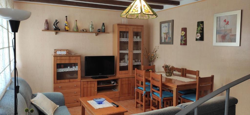 - un salon avec une table à manger et une télévision dans l'établissement Casa Rural Julia, à Lumbrales