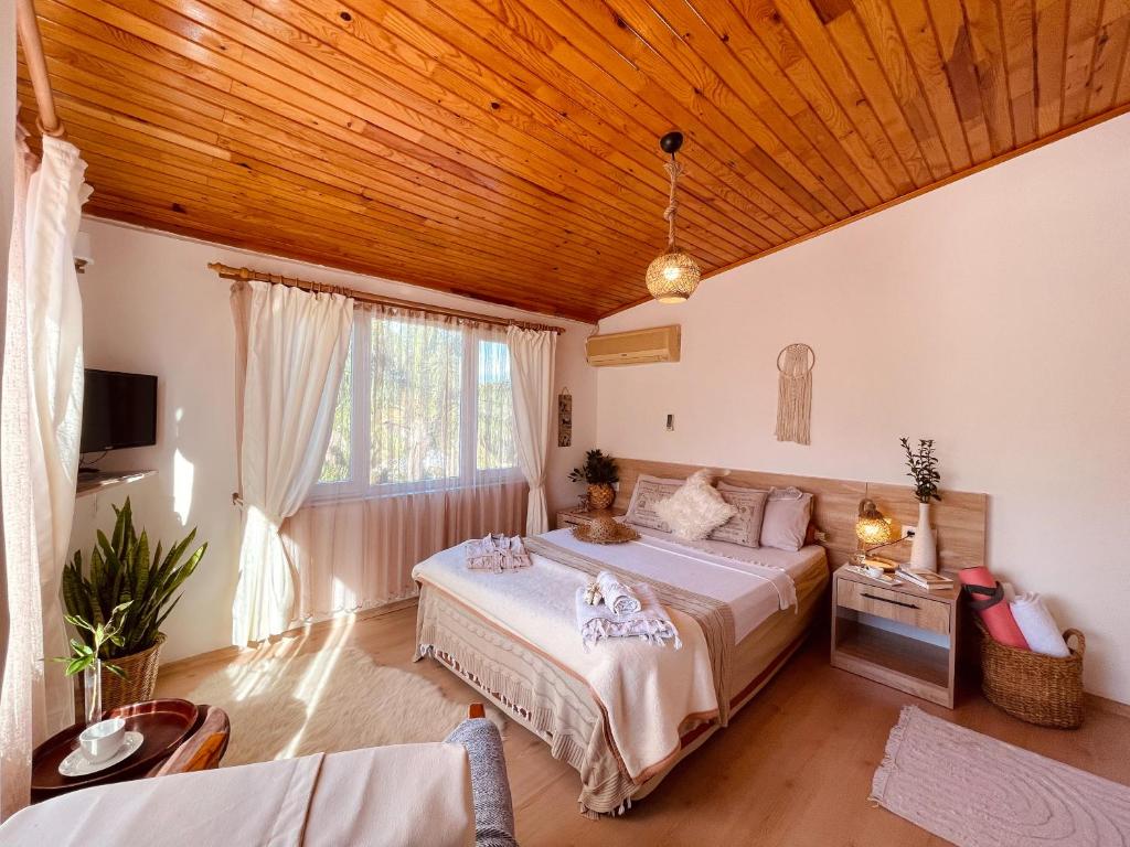1 dormitorio con cama y techo de madera en Oase Garden Hotel en Cıralı