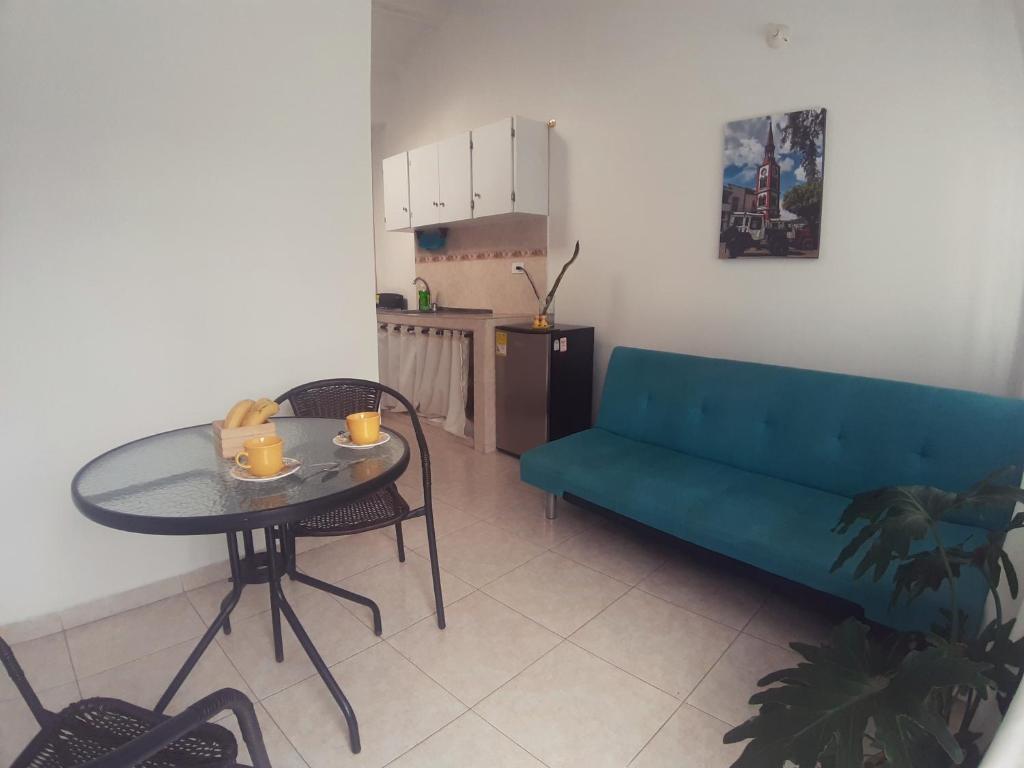 ein Wohnzimmer mit einem blauen Sofa und einem Tisch in der Unterkunft Apartamento amoblado en La Tebaida, Quindio in La Tebaida