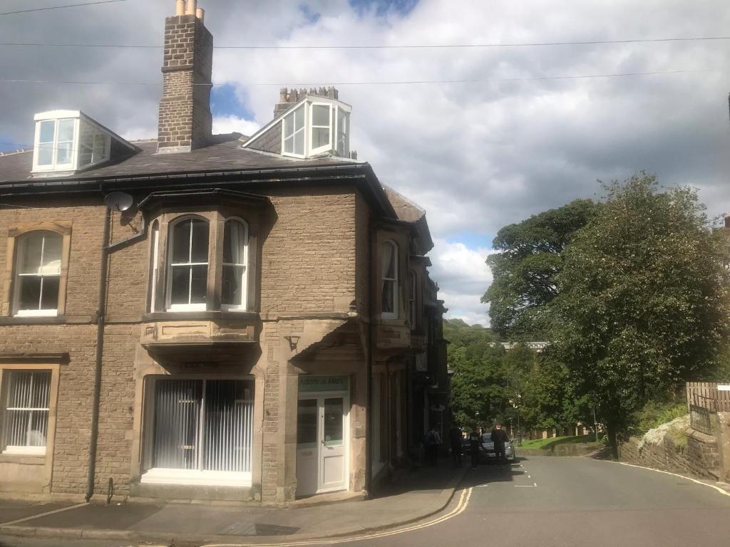 an old brick house on the side of a road at Crescent Bank in Buxton