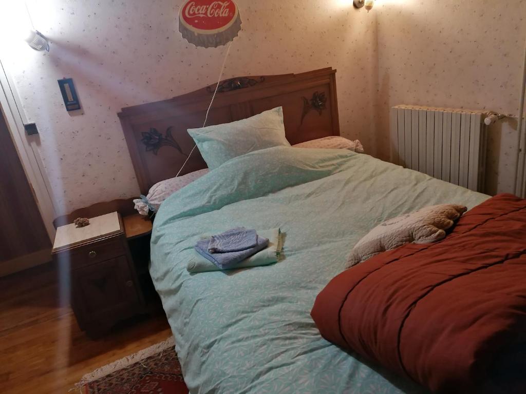 a bedroom with a bed with a cocacola sign on the wall at Sam Bott in Chambon-sur-Voueize