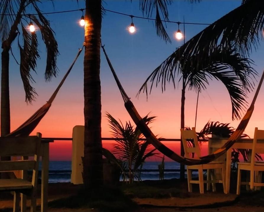 拉斯佩尼塔斯的住宿－Casita de Playa BOMALU，日落时在海滩上的吊床