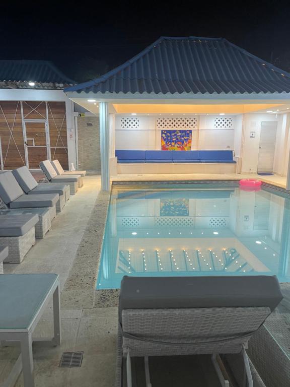 a large swimming pool with chairs around it at night at Casa Dimares in Cartagena de Indias