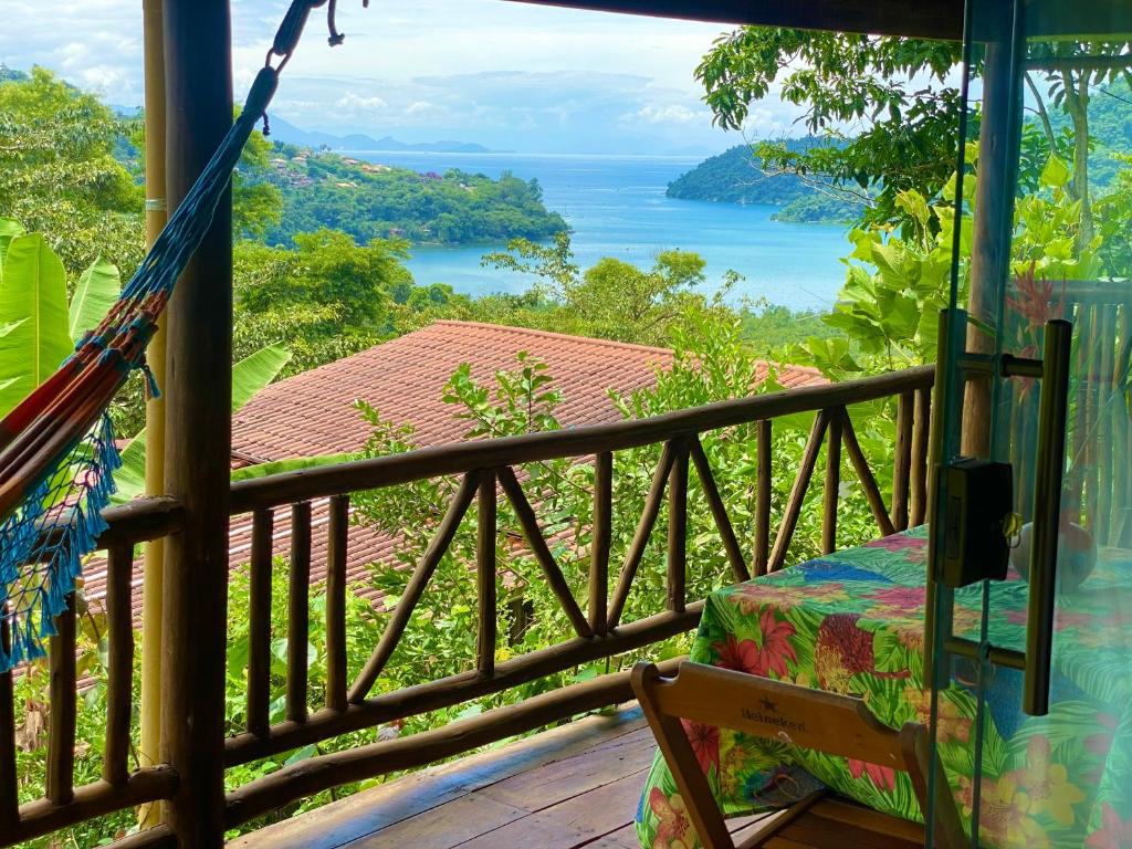 a hammock on a porch with a view of the ocean at Casa Tambor Paraty in Paraty
