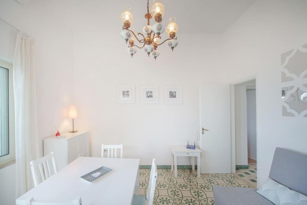 a dining room with a table and a chandelier at Il Gelso in Anacapri