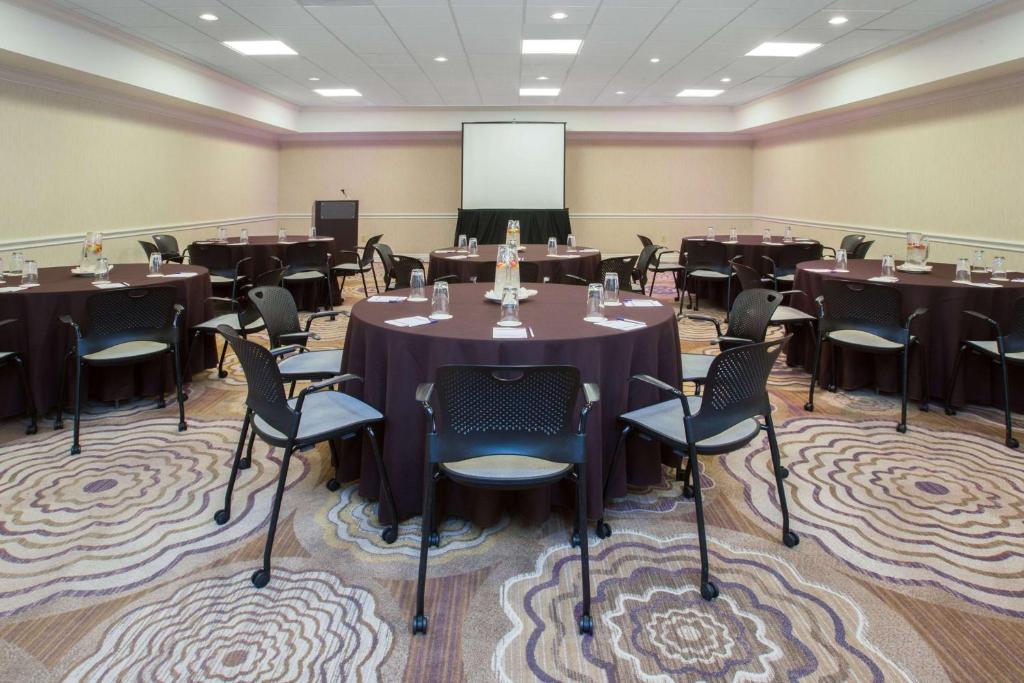 a conference room with tables and chairs and a whiteboard at Sonesta Atlanta Airport North in Atlanta