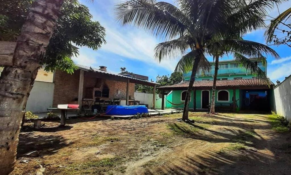 ein Haus mit einer Palme davor in der Unterkunft 4 Estações Arraial - Casa Verde in Arraial do Cabo