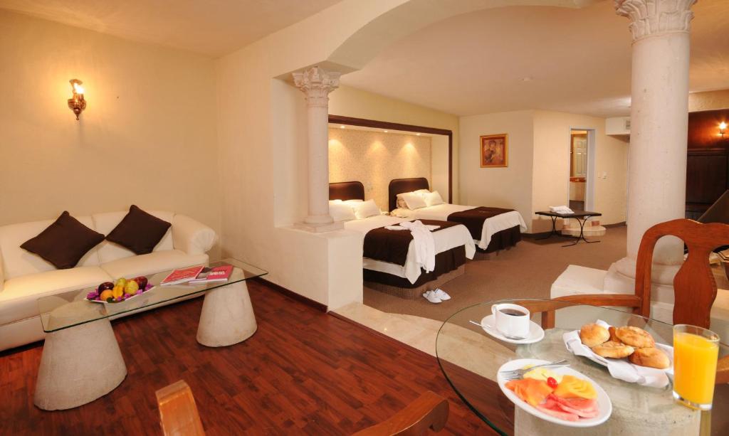 - un salon avec un canapé et un lit dans une chambre dans l'établissement Hotel & Spa Hacienda Baruk, à Zacatecas