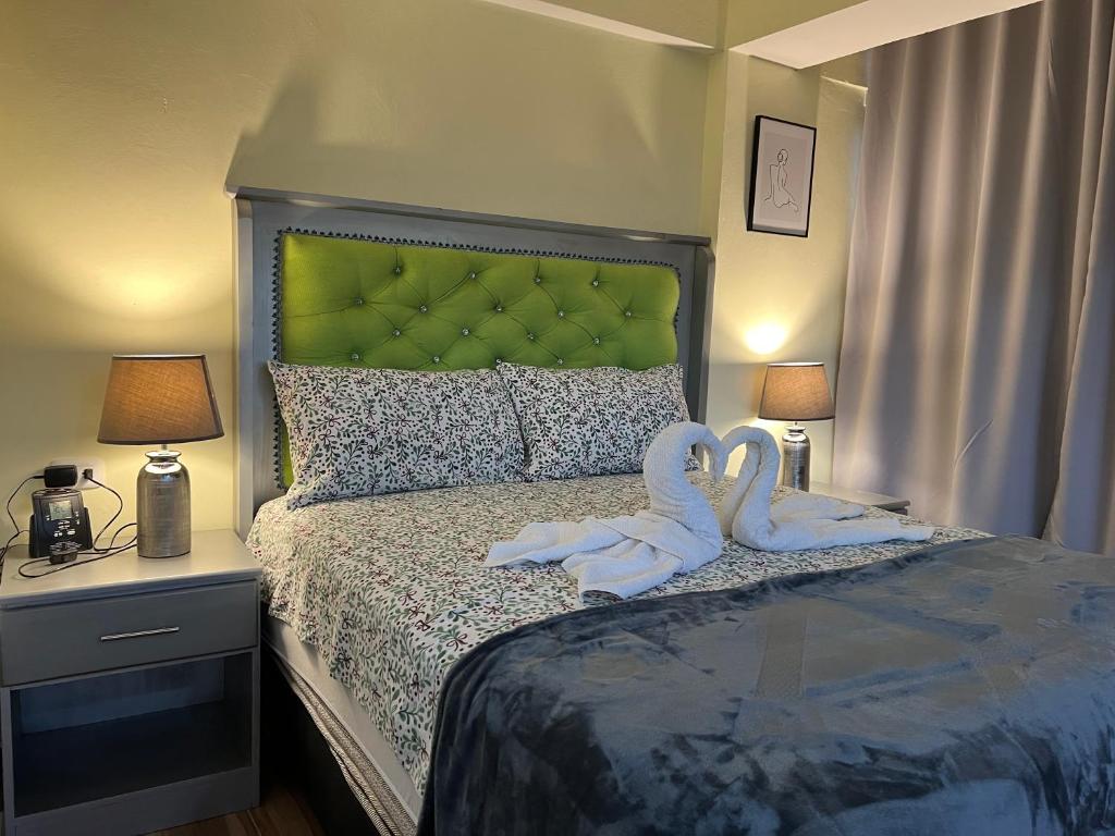 two swans sitting on a bed in a bedroom at Hotel María Bonita Higüey, Apartments in Higuey