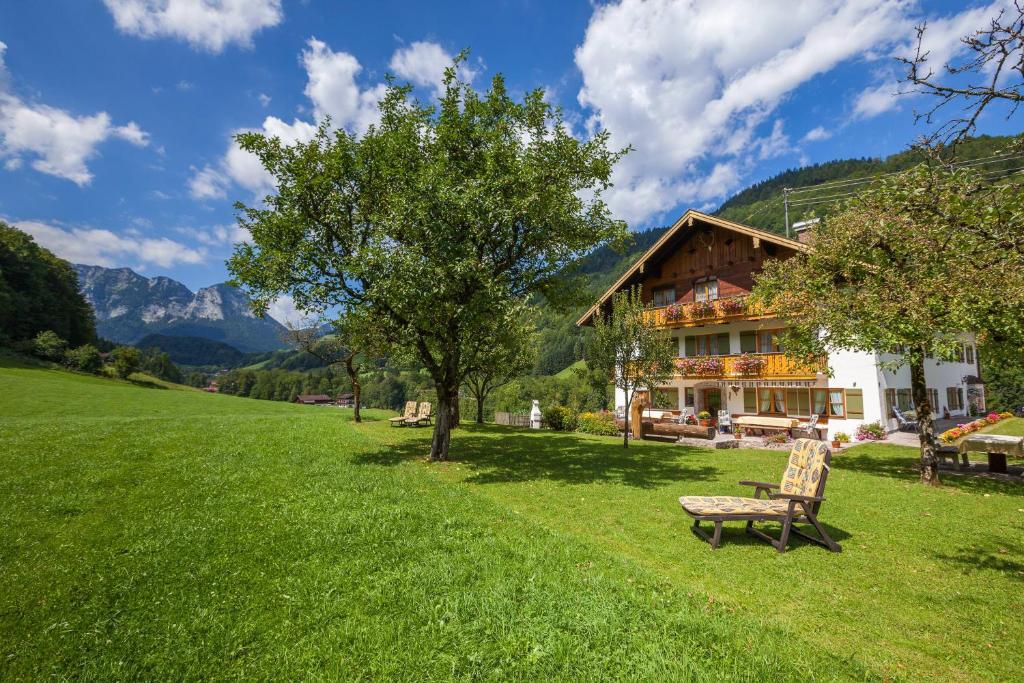 eine Bank im Gras vor einem Haus in der Unterkunft Gästehaus Anfanglehen in Ramsau bei Berchtesgaden