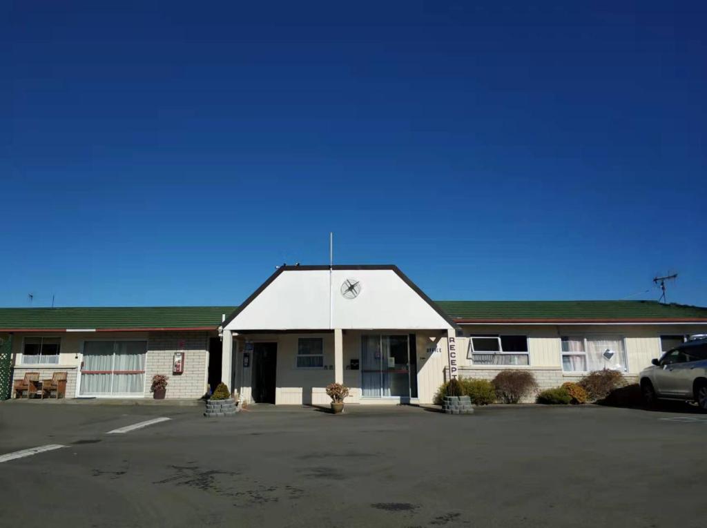 a building with a car parked in a parking lot at Astral Motel in Whanganui