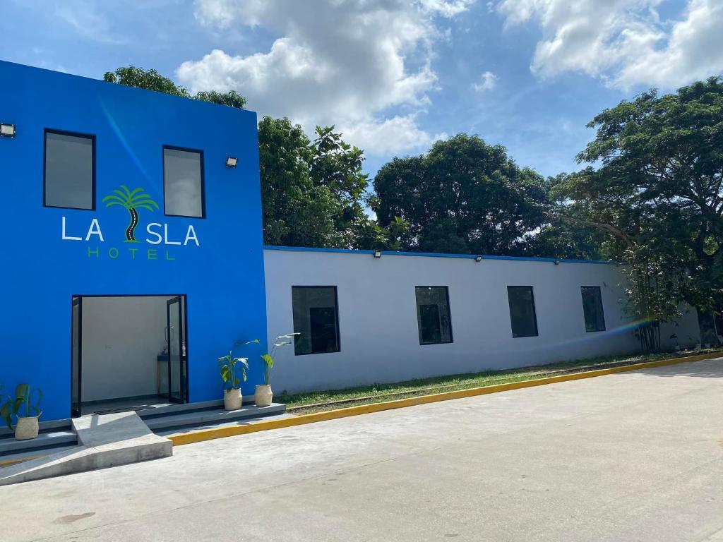 un bâtiment bleu et blanc avec un panneau sur lequel figure un panneau dans l'établissement Hotel La Isla, à Cunduacán