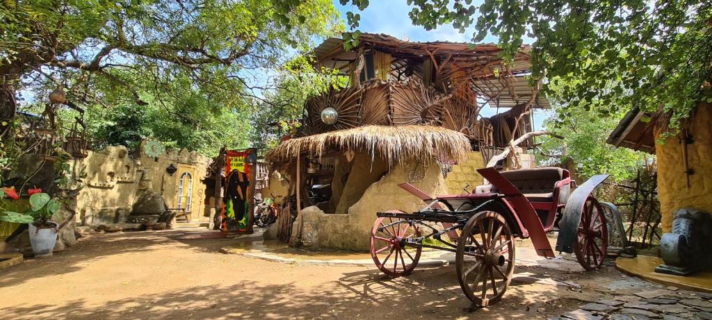 uma carruagem puxada por cavalos estacionada em frente a um edifício em Jungle river humbhaha hostel em Kataragama